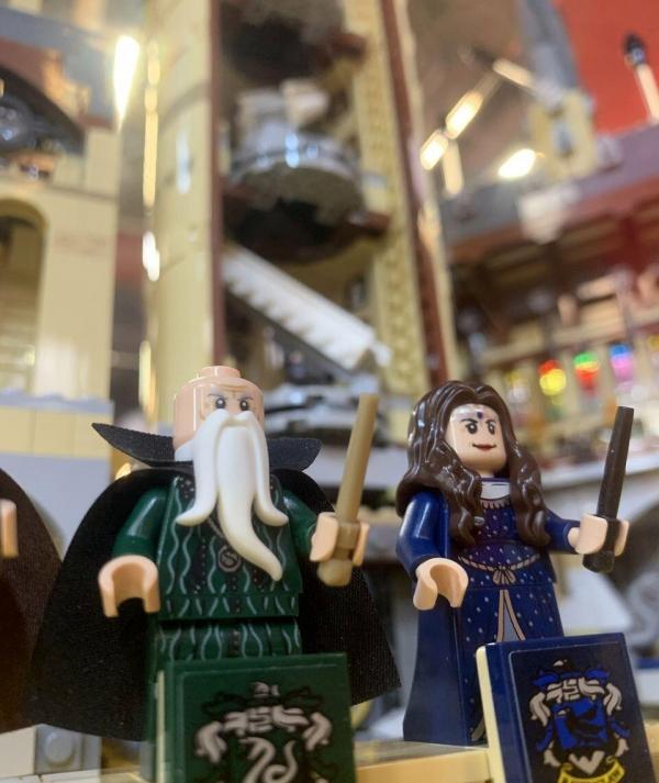 Mardekár Malazár és Hollóháti Hedvig a Roxfort négy alapítója közül, varázspálcával és házcímerrel a kastély díszletei előtt.